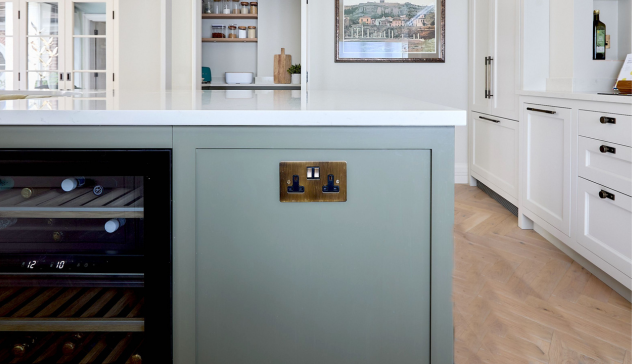A sleek kitchen island with integrated power outlets, offering convenient access for small appliances and mobile charging while maintaining a clean look.